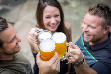 Friends celebrating and cheering with beer pints for National Beer Lover's Day.