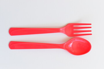 red spoon and fork isolated on white background, plastic cutlery for picnic