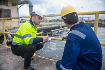 An engineer and a technician are working together to check the operation of the water treatment...
