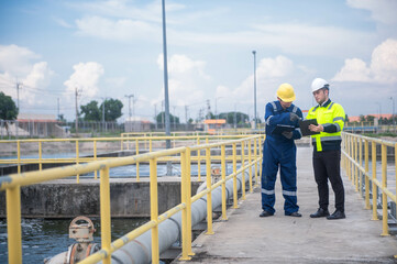 An expert inspector and technicians are seriously checking the water quality in the treatment pond...