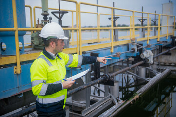 A professional inspector is checking the water filtration system of a wastewater treatment plant to...