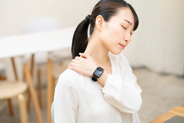 仕事中に肩こりを気にする女性
