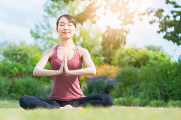 緑あふれる公園でヨガをする若い女性