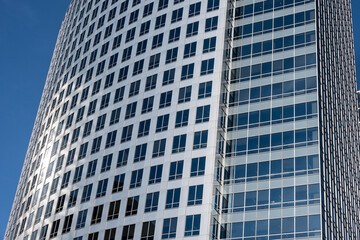 Obraz premium Clean modern city background, new modern glass and silver metal building skyscraper on a sunny blue day, symbol of finance, business, and technology 