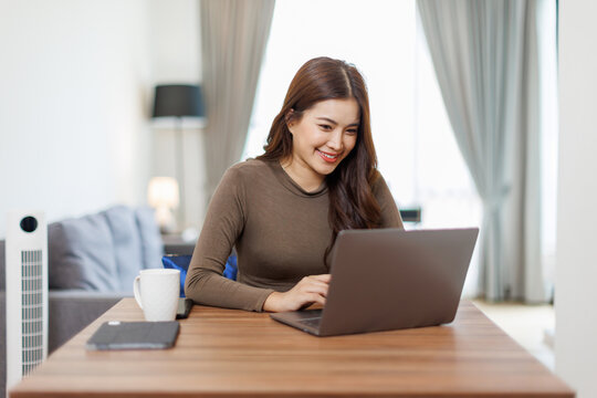 Image of young asian happy cheerful cute beautiful business Asian woman sit indoors in home office using laptop computer work in a video conference on line
- Powered by Adobe