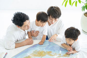 Fototapeta premium 地図を使って楽しく勉強する親子・地図を使って旅行の計画を立てる親子