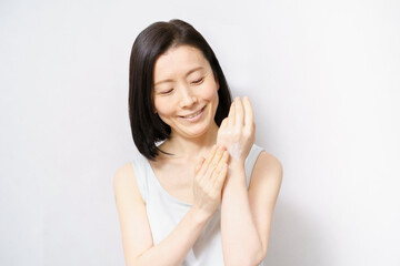 手の甲にクリームを塗る女性