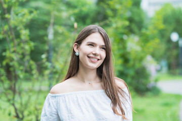Fototapeta premium リラックスした表情で緑地を散歩する若い女性