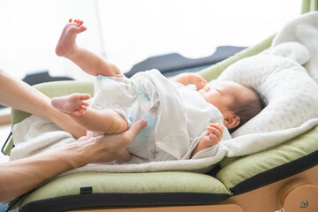 赤ちゃんのオムツを替えるお母さん