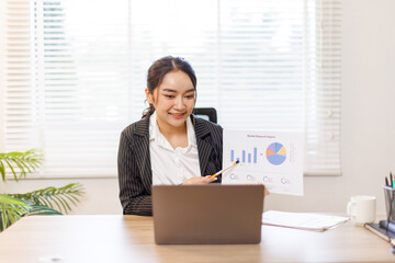 Financial Business asian woman analyze the graph of the company's performance to create profits and...