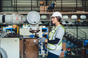 Industrial engineers collaborate in a high-tech factory environment, inspecting robotic machinery...