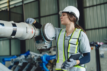 Industrial engineers collaborate in a high-tech factory environment, inspecting robotic machinery...