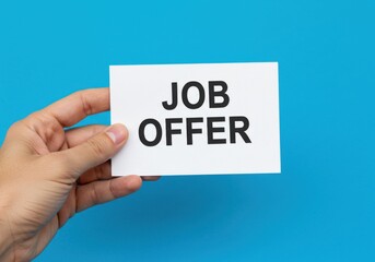 Hand holding card with job offer text on blue background.