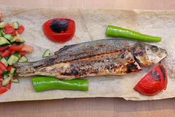 Grilled fish served with fresh vegetables and rice