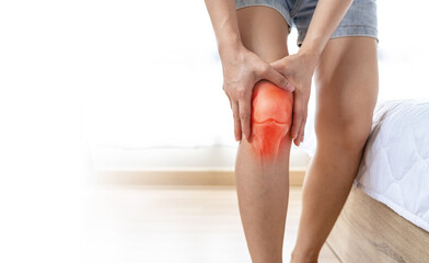 Woman hands touching her knee area. Bone pain, Trauma or Torn ligament in the knee area. Healthcare and medical concept