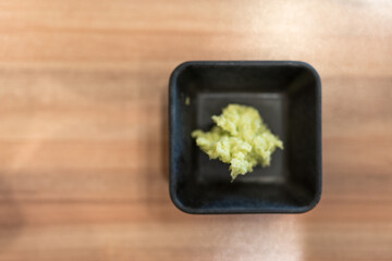 Hot wasabi paste in black bowl on wood table