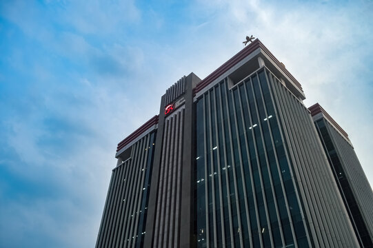 office building belonging to the Indonesian financial services authority (OJK) with a cloudy blue sky in the background, indonesia, 17 November 2023.