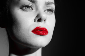 Black and white portrait of a woman with red lips, showcasing beauty and elegance in a minimalistic style. The contrast highlights her expression and features.