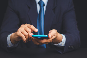Businessman in suit using smartphone, digital communication and productivity concept.