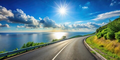 Asphalt road curves gently along a scenic coastal route, offering breathtaking views of a tranquil ocean under a vibrant sunlit sky
