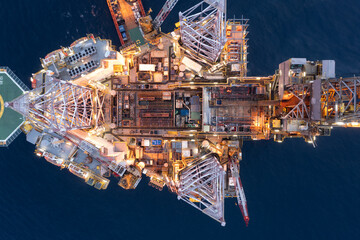 Aerial view of offshore jack up drilling rig during sunset - oil and gas industry.