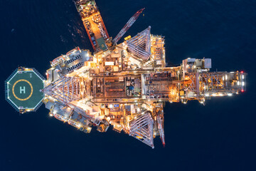 Aerial view of offshore jack up drilling rig during sunset - oil and gas industry.