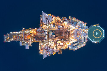 Aerial view of offshore jack up drilling rig during sunset - oil and gas industry.