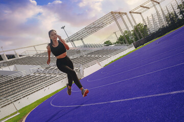 Fit young woman running sprinting at the racetrack. Fit runner fitness runner during outdoor...