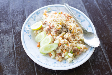 Crab fried rice placed on a plate on a wooden table.