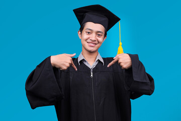 Proud Asian Student Guy Pointing at Himself as Graduated Bachelor Isolated on Blue Background