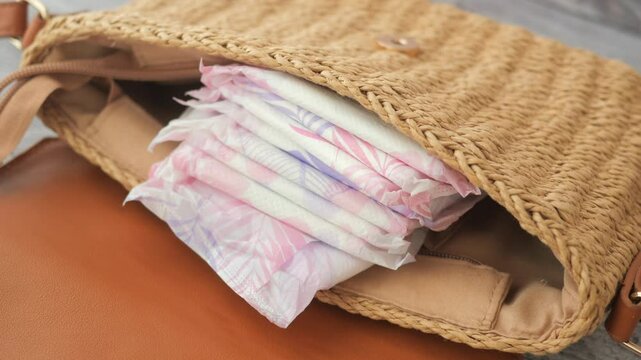 sanitary pad in a woman purse on table 