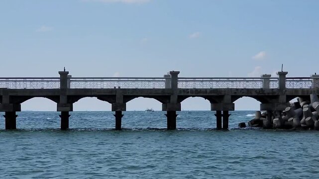 Concrete Seaside Pier Over Clear Blue Ocean Water