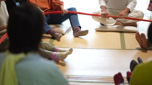 輪になって布を引っ張り合う様子
