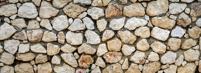 Light brown embossed stone on cement wall for abstract background and texture for interior or exterior design. Beautiful patterns, banner, Panorama wallpaper close up.