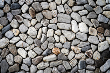 Embossed stones on cement wall for abstract background and texture for interior or exterior design. Beautiful patterns, space for work, banner, wallpaper close up.