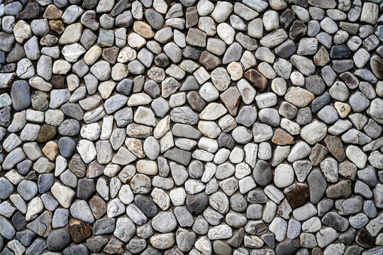 Embossed stones on cement wall for abstract background and texture for interior or exterior design. Beautiful patterns, space for work, banner, wallpaper close up.