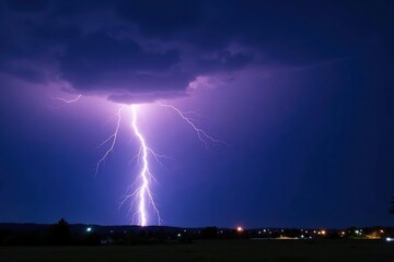 Dramatic bolt of lightning striking a dark stormy sky at night , intense, clouds