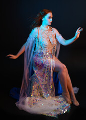 Fantasy studio portrait of a red-haired mermaid faery model wearing a white pearl gown, fairytale...