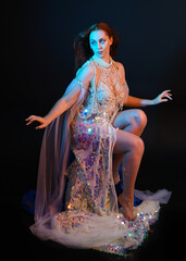 Fantasy studio portrait of a red-haired mermaid faery model wearing a white pearl gown, fairytale...