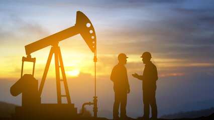 Oil Pump Jack and Workers Silhouette at Sunset