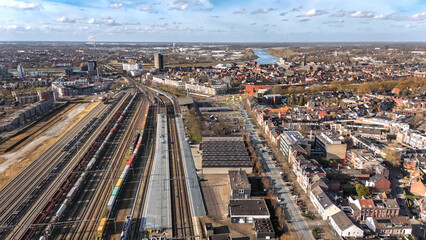 Fototapeta premium Railroad, train tracks and trains aerial drone view from above, railway station in the Netherlands, transportation, logistics and public transport infrastructure concept