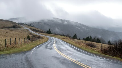 Winding mountain road through a misty landscape.