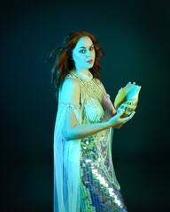 Fantasy studio portrait of a red-haired mermaid faery model wearing a white pearl gown, fairytale...