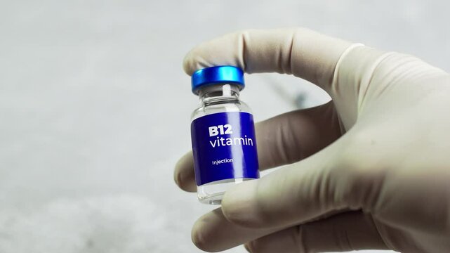 a doctor checks the vitamin b 12 in a vial and shows it to the camera. health and medical concepts.