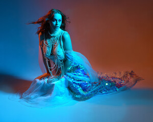 Fantasy studio portrait of a red-haired mermaid faery model wearing white pearl gown, fairytale...