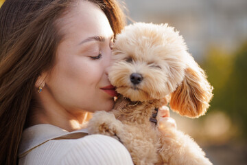 Tender embrace between woman and dog, soft daylight moment of love and loyalty.