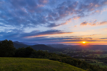 Breathtaking sunset illuminating rolling hills and valleys in the countryside