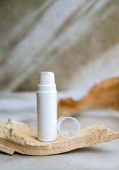Face cream in a white  bottle on shadows background 