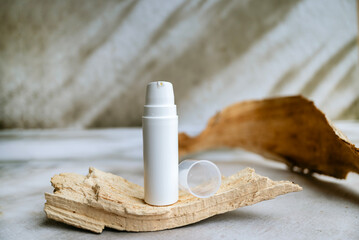 Face cream in a white  bottle on shadows background 