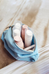 Skincare bag with face creams in a white bottles  on shadows background 